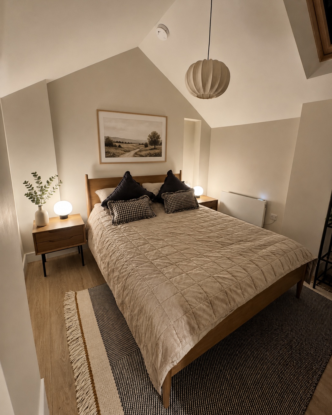 Calm bedroom with oak furniture, linen bedding and soft lamplight